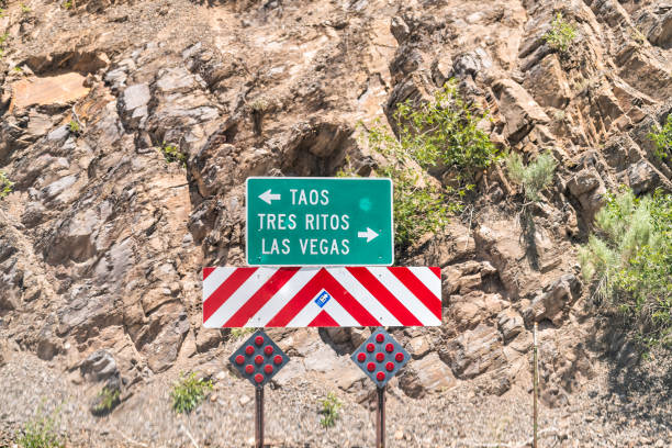 high road à taos rue historique dans les montagnes avec signe directionnel pour taos, tres ritos et las vegas - new mexico sign santa fe new mexico road trip photos et images de collection