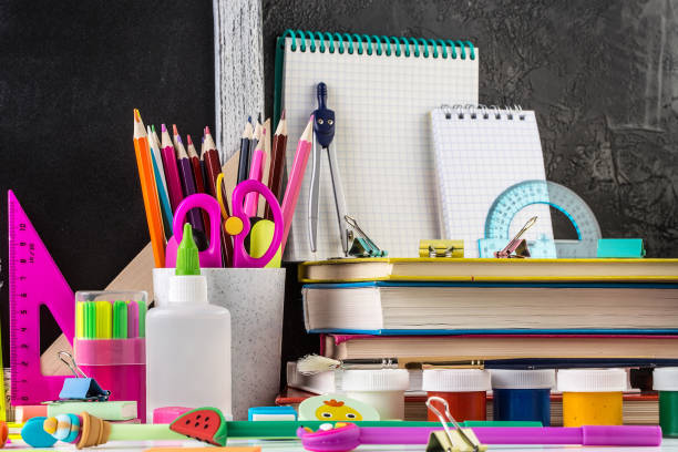 istock Stationery on a table in front of blackboard. 1168624743