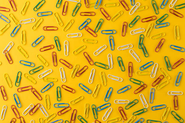 istock A multicolored paper clips on a yellow background, office concept 1168624765