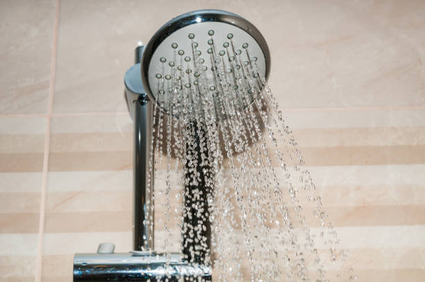 istock Shower head close up with water drops flowing 1168631431