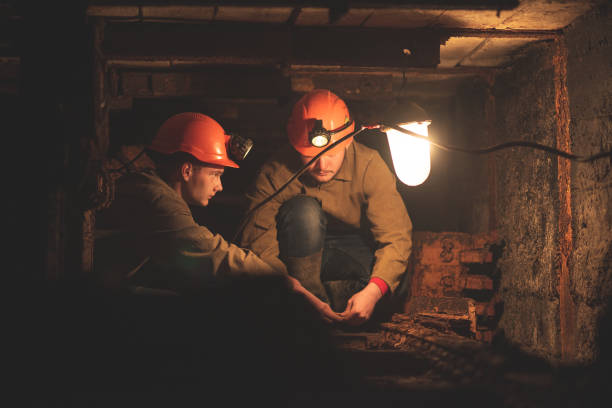 istock Two young guys in a working uniform and protective helmets, sitting in a low tunnel. Workers of the mine 1168632652