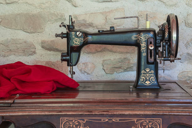 Vintage sewing machine and red fabric close up