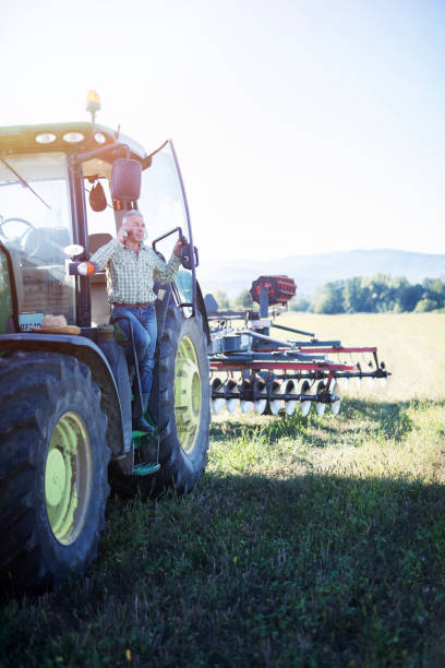 istock Senior farmer standing on tractor and talking on the phone. 1168637463