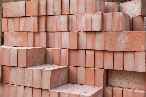 Stack of red bricks on construction site.