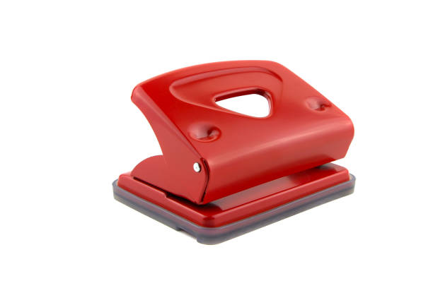 Red office paper hole puncher, isolated on white background