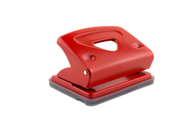 Red office paper hole puncher, isolated on white background Red office paper hole puncher, isolated on white background hole puncher stock pictures, royalty-free photos & images