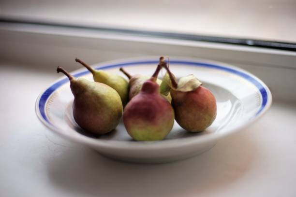 istock five ripe pears in a plate on the windowsill. 1168647463
