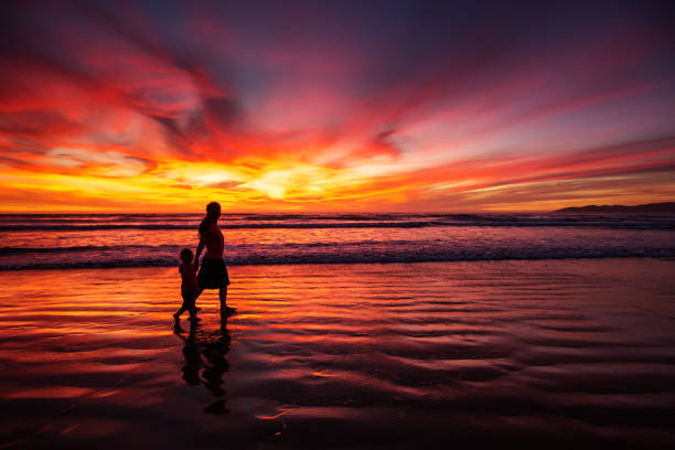 istock mother and son having fun at sunset on the beach 1168649557