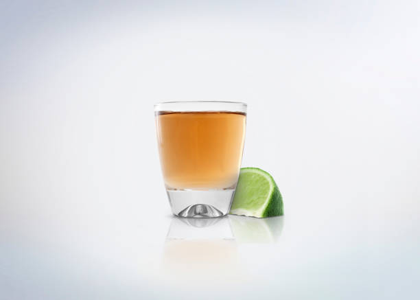 데킬라의 골드 샷. 측면에 레몬 / 라임의 조각알코올 증류음료. - tequila reposado 뉴스 사진 이미지
