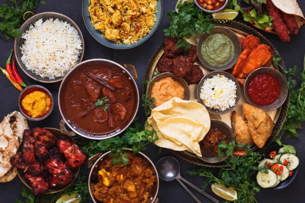 varios platos indios con rogan josh, pollo tikka masala, biryani, pollo tandoori, kebabs y plato mixto con samosa, pakoras, bajis de cebolla, poppadoms, naan y salsas - comida hindú fotos fotografías e imágenes de stock