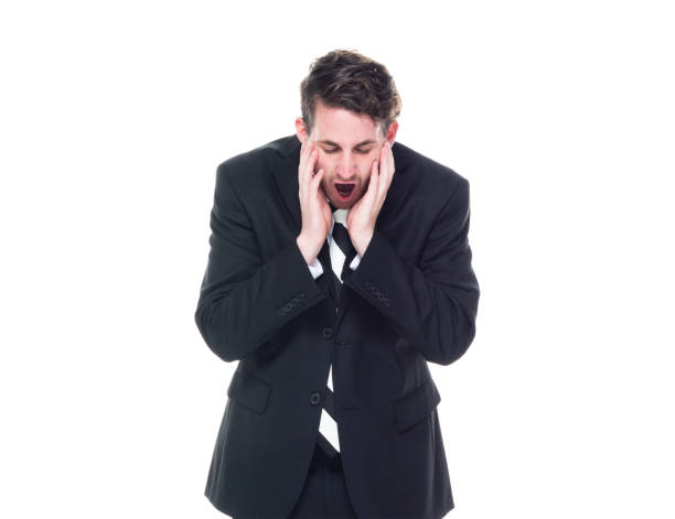 istock Good looking young businessman standing on white background - tired 1168660020