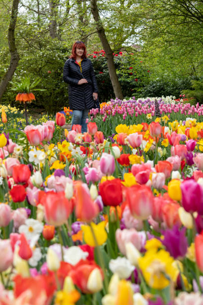 istock Woman in the park between tulips 1168661394