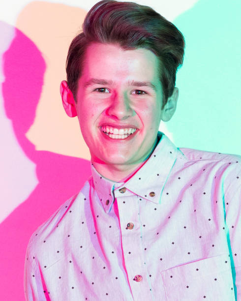 istock Handsome young man standing against white wall with colorful shadows 1168664320