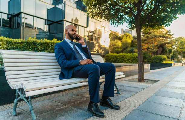 istock Indian businessman holding mobile phone wearing blue suit 1168670638