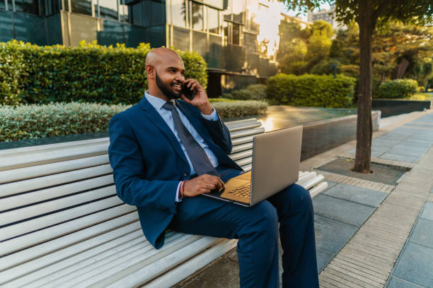 istock Indian businessman holding mobile phone wearing blue suit 1168670675