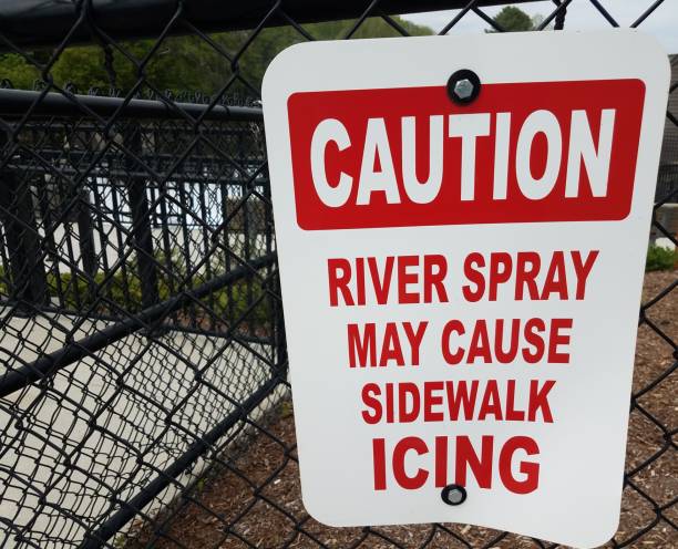 istock caution river spray may cause sidewalk icing sign on fence 1168671280