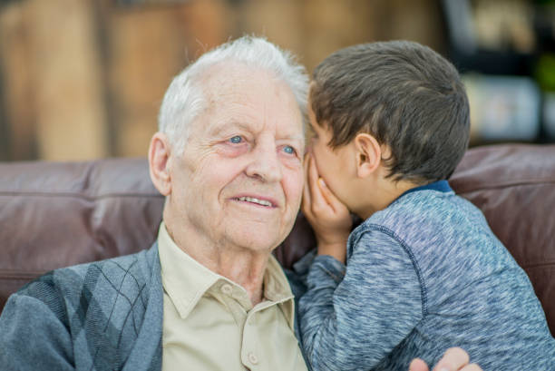 hablando con el abuelo - whispering grandparent child grandfather fotografías e imágenes de stock