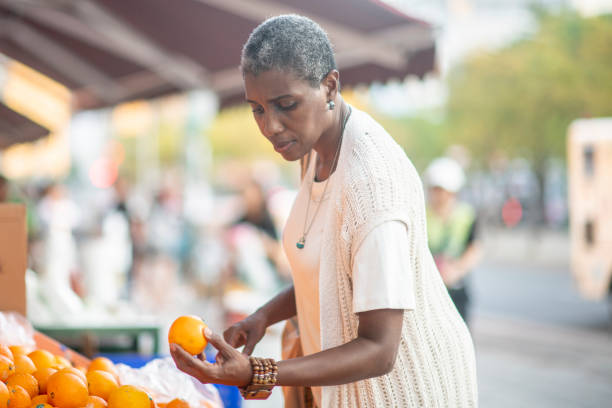 istock Senior woman buying oranges 1168671528