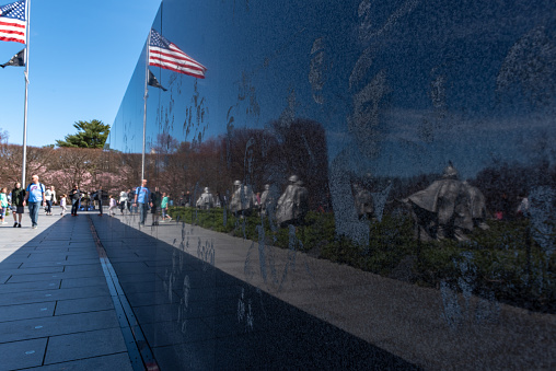 Tourists are visiting the Korean War Veterans Memorial.\nThe Korean War Veterans Memorial that commemorates those who served in the Korean War. Located in West Potomac Park, southeast of the Lincoln Memorial. Washington DC, USA.
