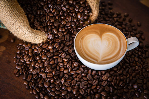 istock cup of coffee and coffee beans  on dark background, top view 1168675848