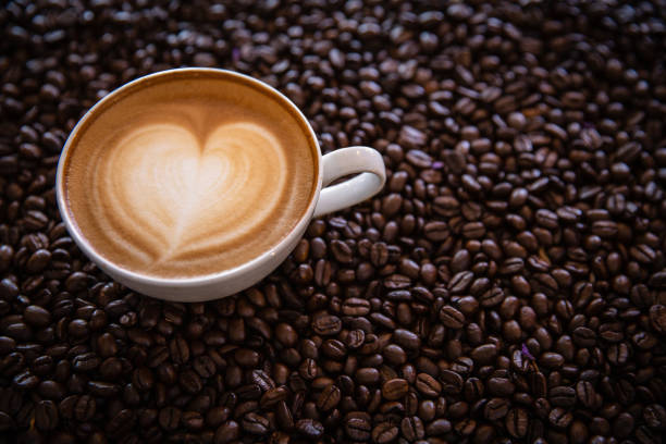istock cup of coffee and coffee beans  on dark background, top view 1168675850