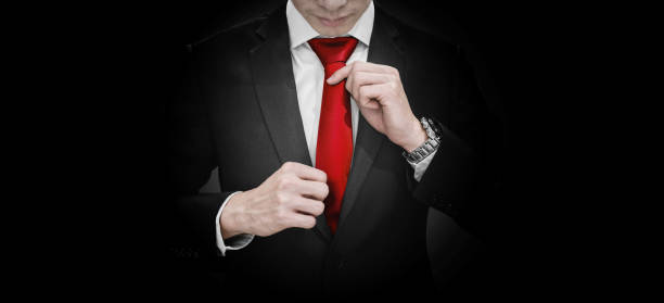 istock Businessman in black suit tying red necktie 1168679466