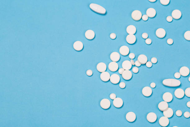 istock Pharmacy theme. white different  Pills and Capsules on the blue Surface. Closeup 1168697139
