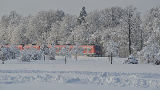 Munich S-Bahn train passes the winter wonderland created by preceding snow storm