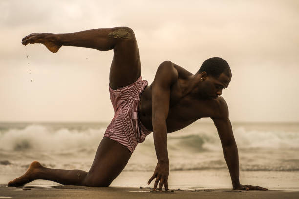 istock contemporary dance choreographer and dancer doing ballet beach workout . a young attractive and athletic black African American man dancing on sunrise doing dramatic performance 1168701250