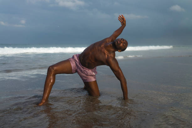 istock contemporary dance choreographer and dancer doing ballet beach workout . a young attractive and athletic black African American man dancing on sunrise doing dramatic performance 1168701392