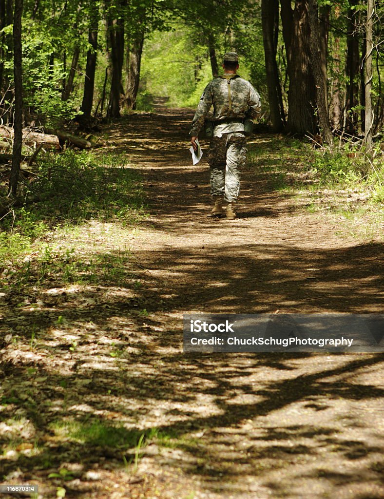 Soldier Military Camouflage Orienteering Forest Trail Military infantry soldier in camouflage walking and orienteering along shaded forest trail. Adult Stock Photo