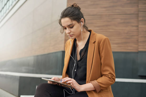 istock Young woman with tablet working outdoor 1168715052