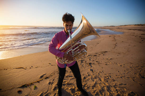 istock Musician plays a wind instrument standing on the ocean coast. 1168722237
