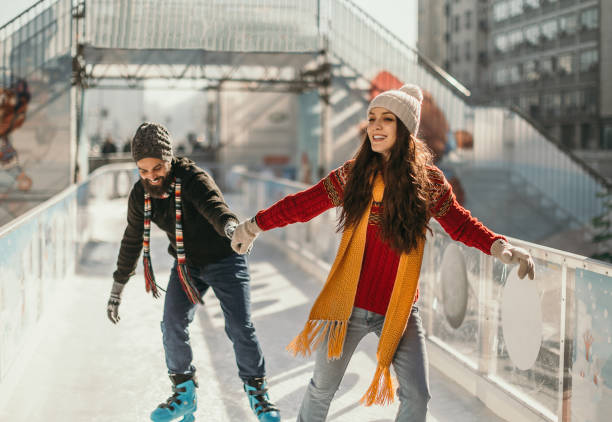 pares felizes novos que patinam junto - fun knit hat adult dating - fotografias e filmes do acervo