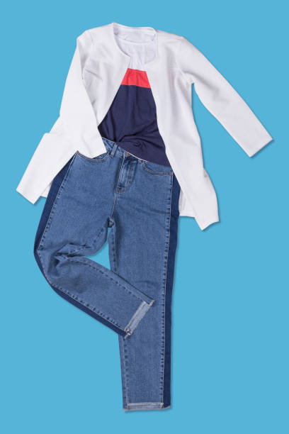 istock blue jeans and a white jacket laid out on a blue background, shopping concept 1168722429