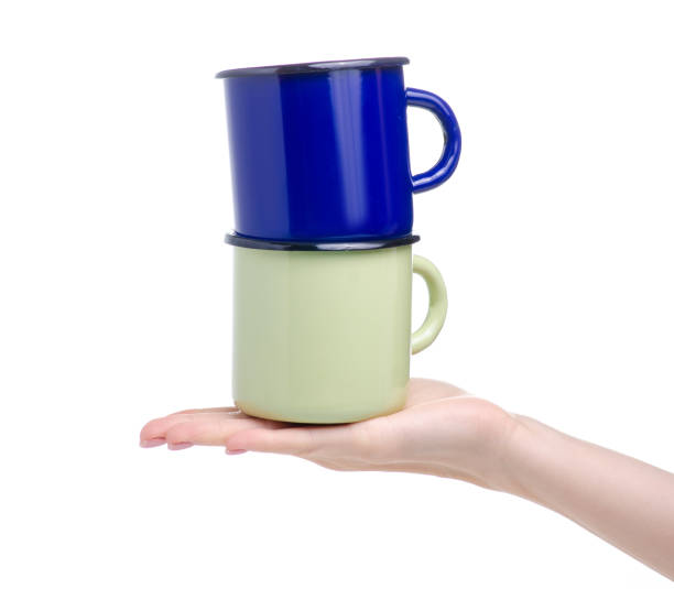 istock Green and blue enamel cup in hand 1168723772