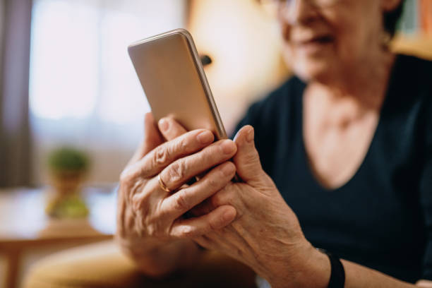 istock Portrait of senior woman's hands at home using mobile phone 1168727721