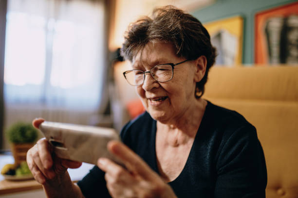 istock Portrait of senior woman at home using mobile phone and technologies 1168728879