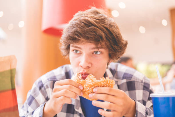 istock grimy smudge funny young guy eating junk fast food 1168729522