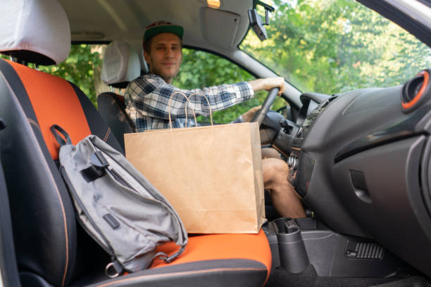 istock courier sit inside the car and move to the client to give the package 1168730872
