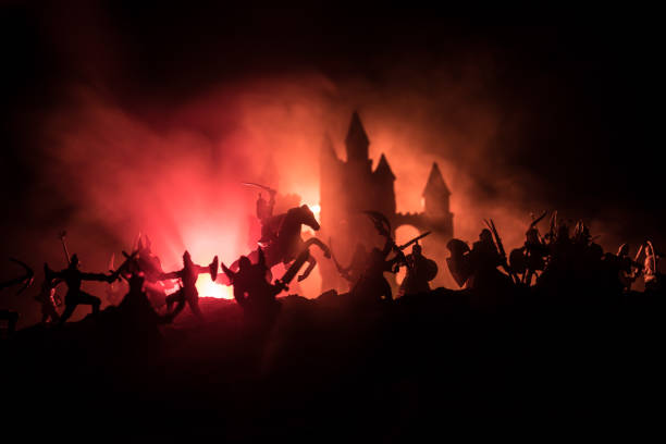 istock Medieval battle scene with cavalry and infantry. Silhouettes of figures as separate objects, fight between warriors on dark toned foggy background with medieval castle. 1168731911