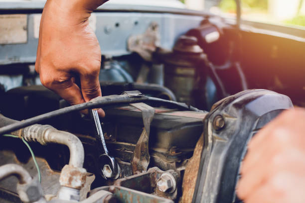 istock Young mechanic working use a wrench and fixing old car 1168731963
