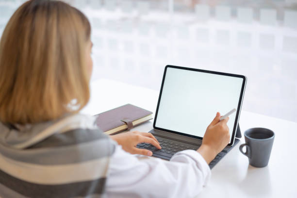 istock Business woman using and typing on mockup white screen laptop at her office. 1168735430