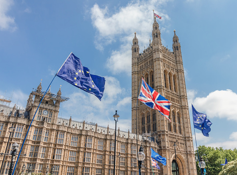 London / UK - June 26th 2019 - European Union and Union Jack flags waving outside UK Parliament