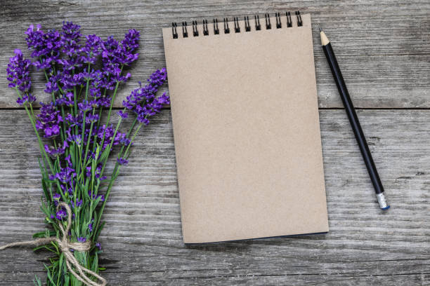 istock Lavender flowers with blank paper notebook and pencil on rustic wooden background. flat lay. mock up 1168742906