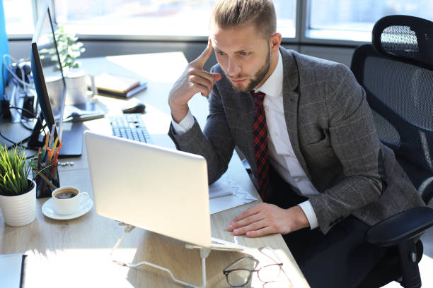istock Young modern business man working using laptop while sitting in the office. 1168747052