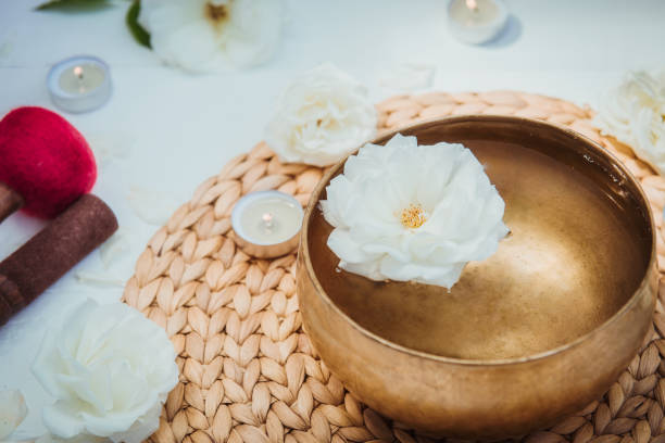 istock Tibetan singing bowl with floating in water rose inside. Special sticks, burning candles, flowers petals on the white wooden background. Meditation and Relax. Exotic massage. Copy space. 1168747434