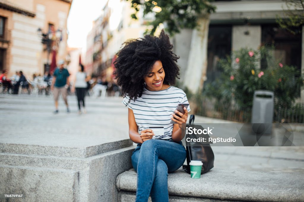 Hermosa chica comprando en línea en la calle - Foto de stock de Tarjeta de crédito libre de derechos