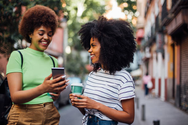 istock Two friends waiting for a taxi and using smartphone 1168749284