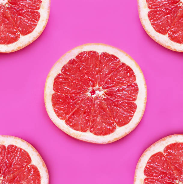 istock Fresh pieces of grapefruit on a pink background. 1168749534